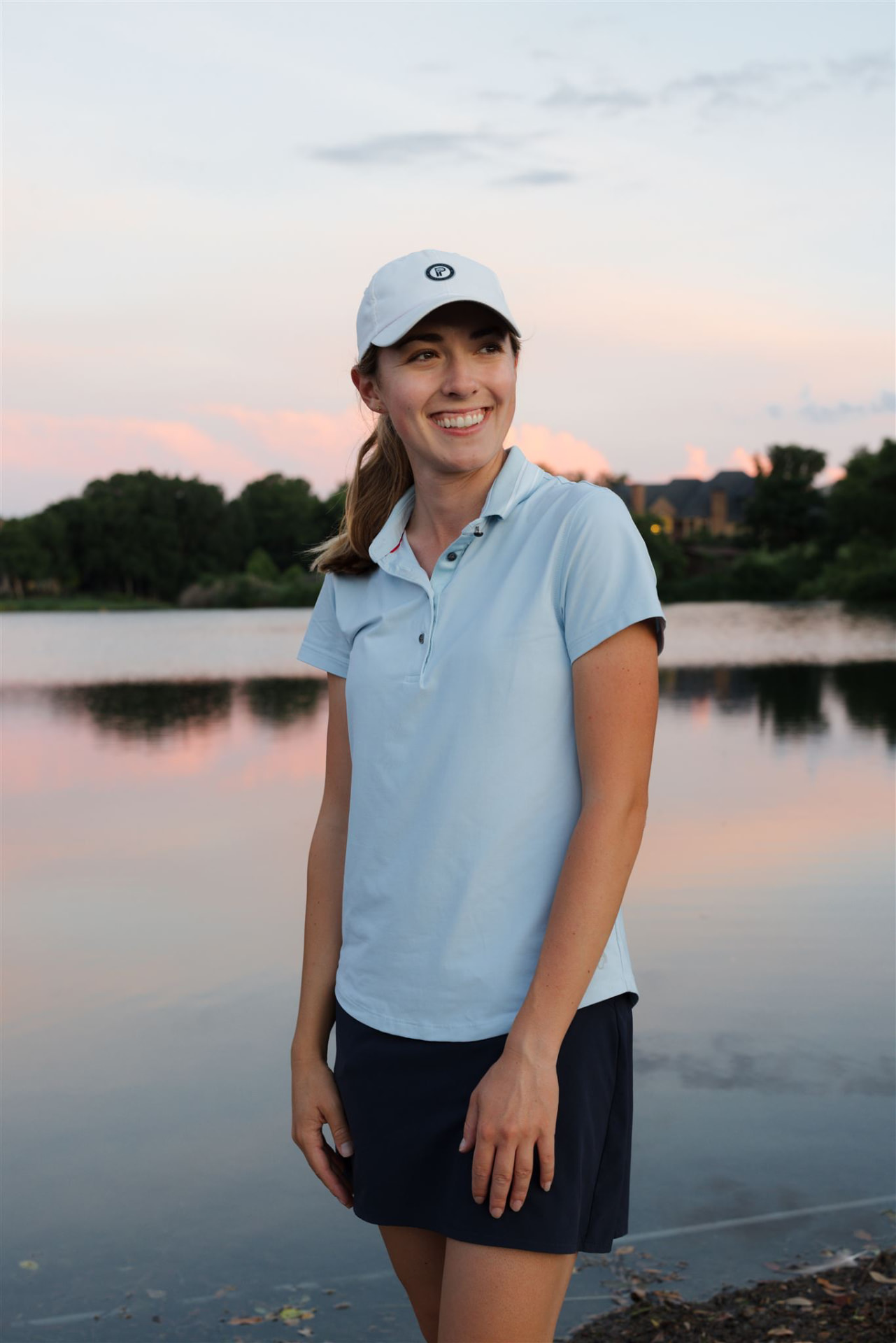 Michelle smiling by the water at sunset