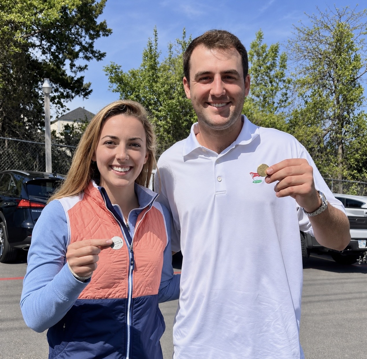 Michelle holding a custom ball marker with Scottie Scheffler